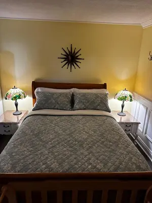 a bedroom with a large bed with two lamps at Blue Gables Bed and Breakfast in Niagara Falls