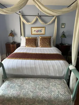 a bedroom with a large bed with a canopy at Blue Gables Bed and Breakfast in Niagara Falls