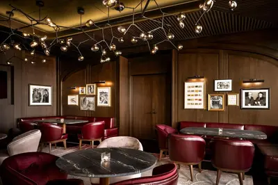 a restaurant with red chairs and tables and lights at Park Hyatt Toronto in Toronto