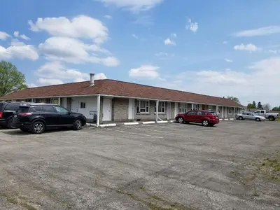 a building with cars parked in a parking lot at Eastwood Motel in Woodstock