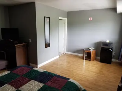 a bedroom with a bed and a wooden floor at Eastwood Motel in Woodstock