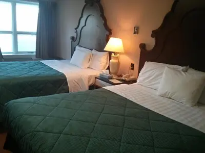 a hotel room with two beds and a lamp at Port Motel in Port Colborne