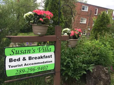 a sign for a bed and breakfast in a garden at Susan's Villa in Niagara Falls