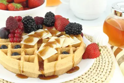 a waffle with fruit on a plate on a table at Susan's Villa in Niagara Falls