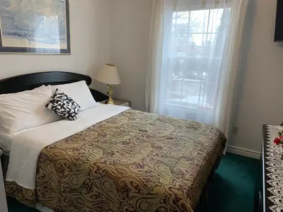a bedroom with a bed and a window at Susan's Villa in Niagara Falls