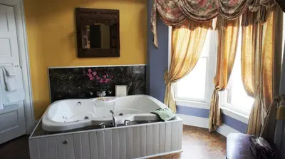 a bath tub in a bathroom with a sink at A Night to Remember B & B in Niagara Falls
