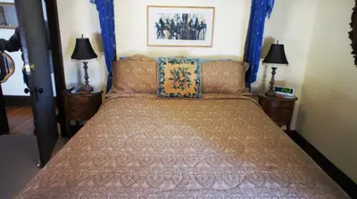 a bedroom with a bed with a blue head board at A Night to Remember B & B in Niagara Falls