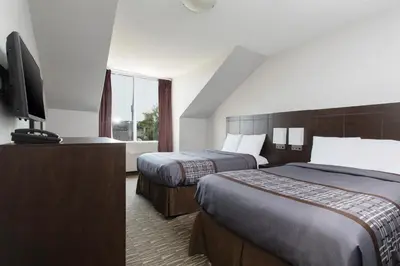 a hotel room with two beds and a flat screen tv at Super 5 Inn in Mississauga