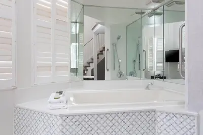 a white bathroom with a tub and a large mirror at Super 5 Inn in Mississauga