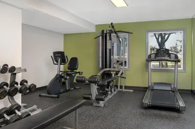 a gym with exercise equipment in a room with green walls at Spark by Hilton Toronto Mississauga in Mississauga