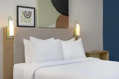 a bed in a hotel room with white pillows at Spark by Hilton Toronto Mississauga in Mississauga