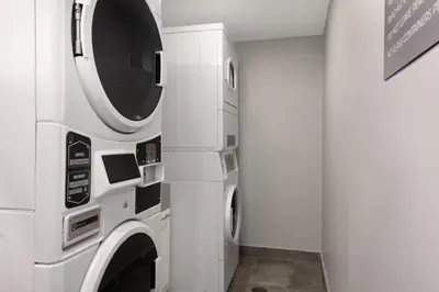 a white laundry room with a washer and dryer at Spark by Hilton Toronto Mississauga in Mississauga