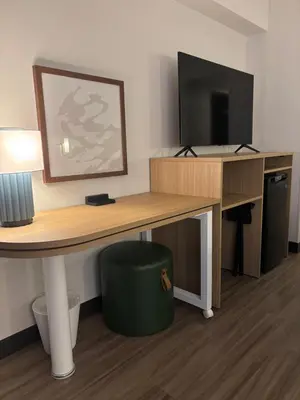 a desk with a computer and a television on it at Spark by Hilton Toronto Mississauga in Mississauga