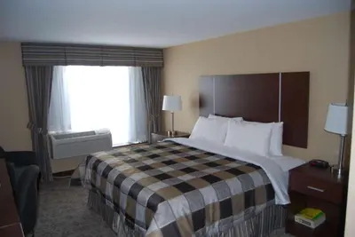 a hotel room with a large bed and a window at Days Inn by Wyndham Brampton in Brampton