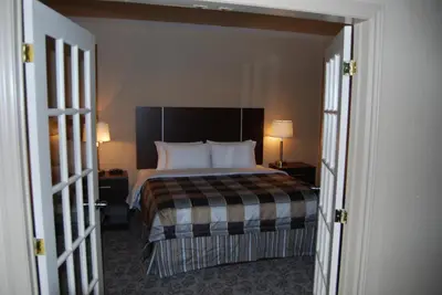 a bedroom with a bed and two lamps and two doors at Days Inn by Wyndham Brampton in Brampton