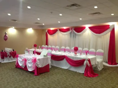 a banquet room with white tables and red and white curtains at Days Inn by Wyndham Brampton in Brampton