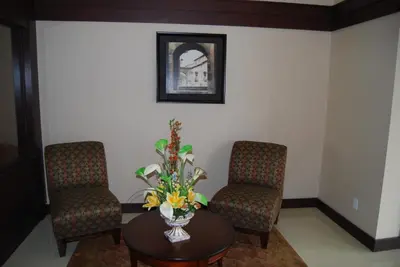 a waiting room with two chairs and a table with flowers at Days Inn by Wyndham Brampton in Brampton