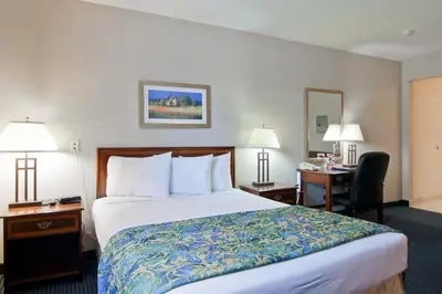 a hotel room with a bed and a desk at Travelodge by Wyndham Trenton in Trenton
