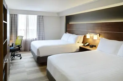a hotel room with two beds and a desk at Holiday Inn Express Toronto Downtown by IHG in Toronto