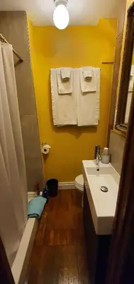 a bathroom with a sink and a toilet and towels at A Moment in Time Bed and Breakfast in Niagara Falls