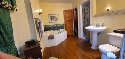 a bathroom with a tub and a sink and a toilet at A Moment in Time Bed and Breakfast in Niagara Falls