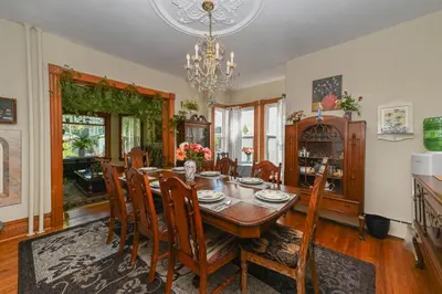 a dining room with a table and chairs and a chandelier at Niagara Inn Bed and Breakfast in Niagara Falls