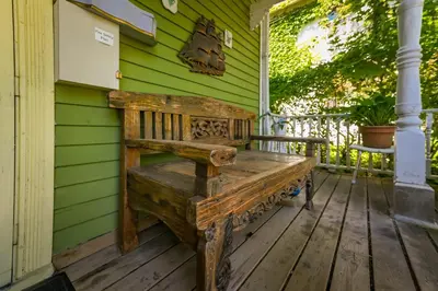 a wooden bench sitting on the front porch of a house at Niagara Inn Bed and Breakfast in Niagara Falls