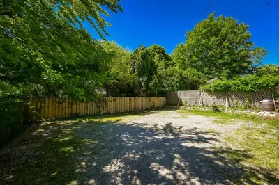 a driveway with a fence and trees in a yard at Niagara Inn Bed and Breakfast in Niagara Falls
