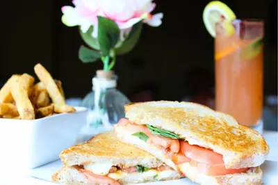 a sandwich and french fries on a table with a drink at Monte Carlo Inn & Suites Downtown Markham in Markham