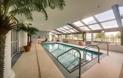 a swimming pool in a building with a glass ceiling at Monte Carlo Inn & Suites Downtown Markham in Markham