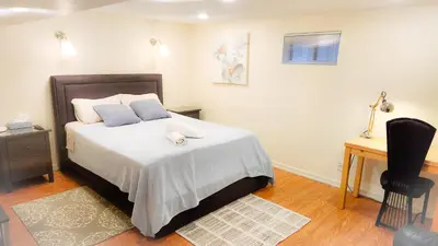 a bedroom with a bed with two pillows and a desk at Richview Gardens Apartment in Toronto
