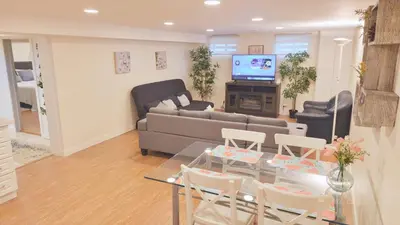 a living room with a couch and a table and chairs at Richview Gardens Apartment in Toronto