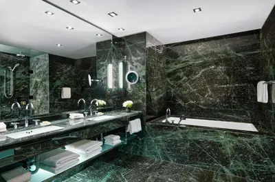 a black marble bathroom with two sinks and a tub at The Hazelton Hotel in Toronto