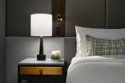 a bedroom with a bed and a table with a lamp at The Hazelton Hotel in Toronto