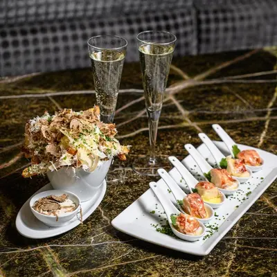 a table with plates of food and two glasses of champagne at The Hazelton Hotel in Toronto