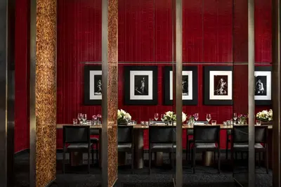 a dining room with red walls and a table with chairs at The Hazelton Hotel in Toronto