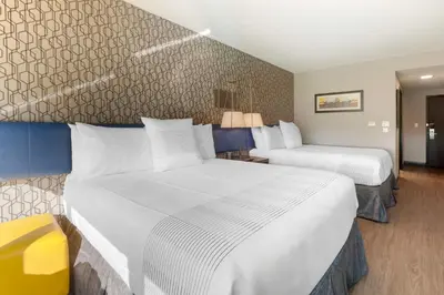 a hotel room with two beds with white sheets at GLō Best Western Mississauga Corporate Centre in Mississauga