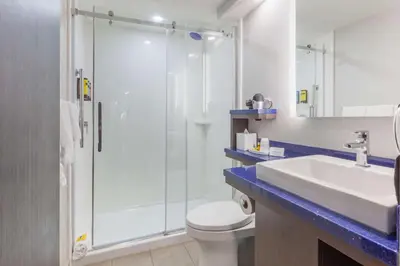 a bathroom with a shower and a toilet and a sink at GLō Best Western Mississauga Corporate Centre in Mississauga