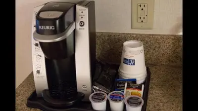 a coffee maker on a counter next to cups at Holiday Inn Express Brampton by IHG in Brampton
