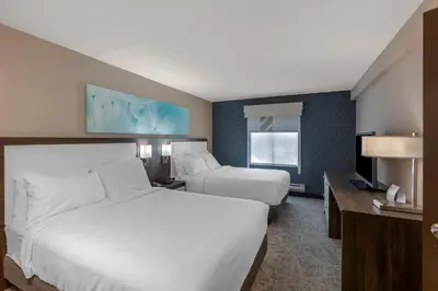 a hotel room with two beds and a television at Executive Residency by Best Western Toronto-Mississauga in Mississauga