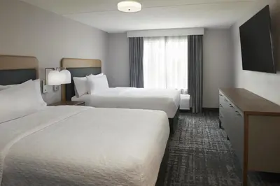 a hotel room with two beds and a television at Homewood Suites by Hilton Toronto Vaughan in Vaughan