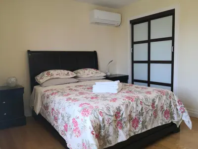 a bedroom with a bed with a floral bedspread at Dairy Homestay in Toronto