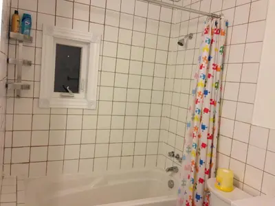 a bathroom with a tub and a shower curtain at Dairy Homestay in Toronto