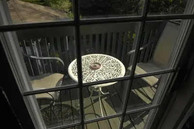 a table and chair sitting on a patio through a window at Butler Creek House in Niagara on the Lake