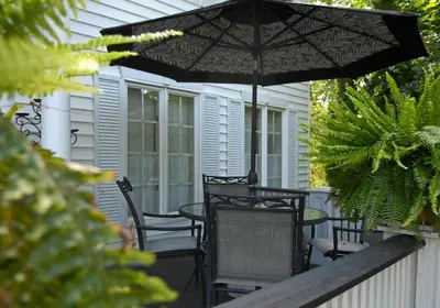 a patio with a table and chairs and an umbrella at Butler Creek House in Niagara on the Lake