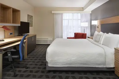 a hotel room with a bed and a desk and a computer at TownePlace Suites by Marriott Oshawa in Oshawa