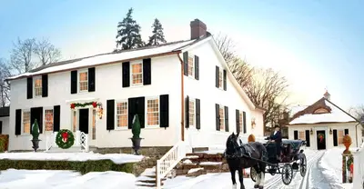 a horse drawn carriage in front of a white house at Old Ivy Walk in Niagara on the Lake