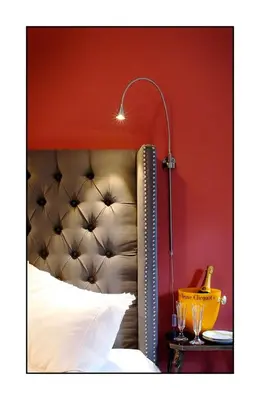 a bedroom with a bed with a lamp on a table at Old Ivy Walk in Niagara on the Lake