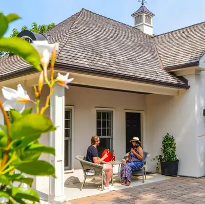two women sitting on the porch of a house at Old Ivy Walk in Niagara on the Lake