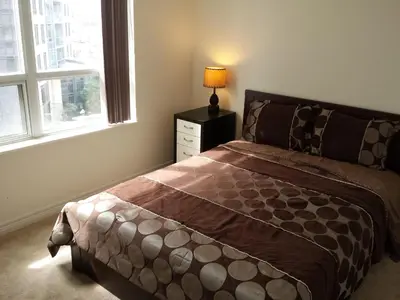 a bedroom with a bed and a lamp on a night stand at 2 Bedroom 1 Bathroom Prime Location in Mississauga in Mississauga